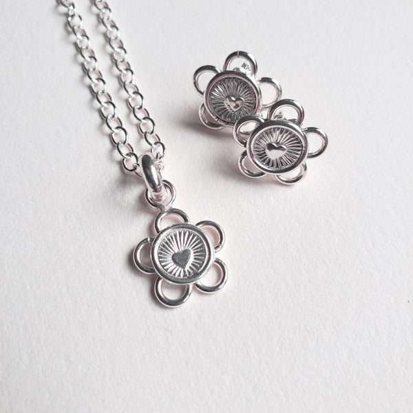 This adorable silver earring and pendant set is handmade from tarnish resistant Argentium 935. It is hand stamped and formed to create these lovely little five loop petal Love Blossoms that are appropriate for casual or dressy occasions. The centre of each blossom is an eye catching radiant heart.