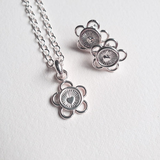 This adorable silver earring and pendant set is handmade from tarnish resistant Argentium 935. It is hand stamped and formed to create these lovely little five loop petal Love Blossoms that are appropriate for casual or dressy occasions. The centre of each blossom is an eye catching radiant heart.